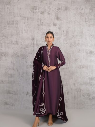 A woman in a purple dress standing in front of a wall