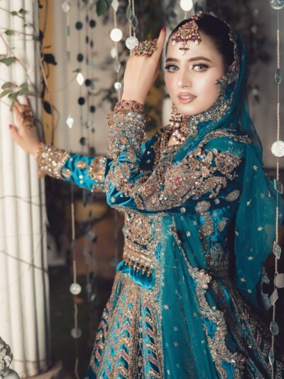 Photo by Naeem Ad A beautiful woman poses in intricate, teal bridalwear.