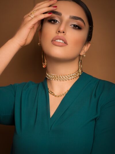 A woman in a green dress holding her hands to her face