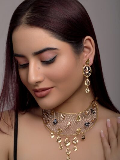 a woman wearing a gold necklace and earrings