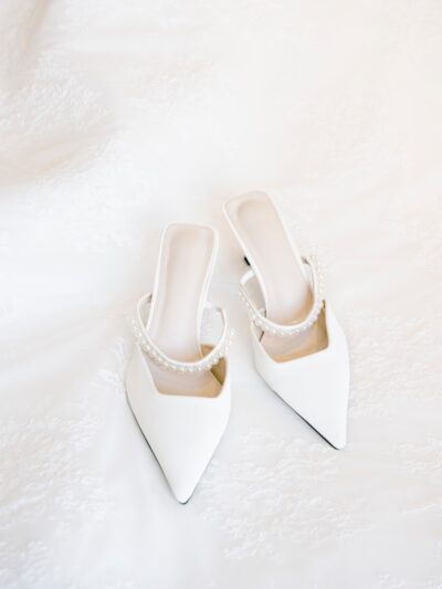 A pair of white shoes sitting on top of a bed