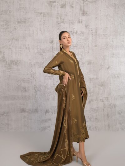 Photo by Shireen Lakdawala A woman in a brown dress standing in front of a wall