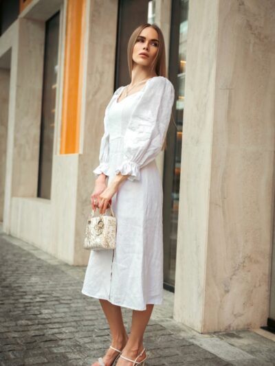Photo by alexanderafan Woman in a white dress is posing outdoors.