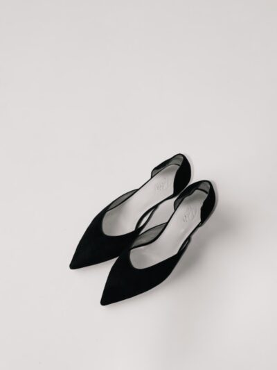 a pair of black shoes sitting on top of a white surface