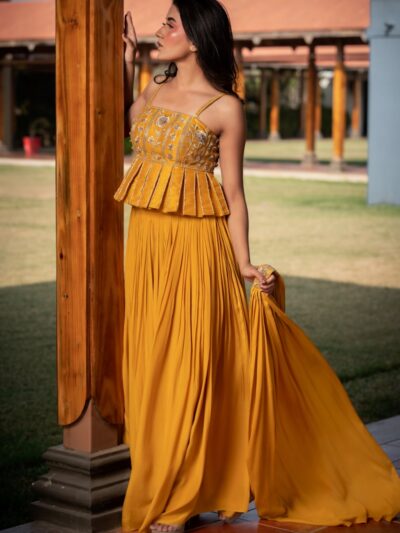 Woman in yellow peplum top and pleated skirt