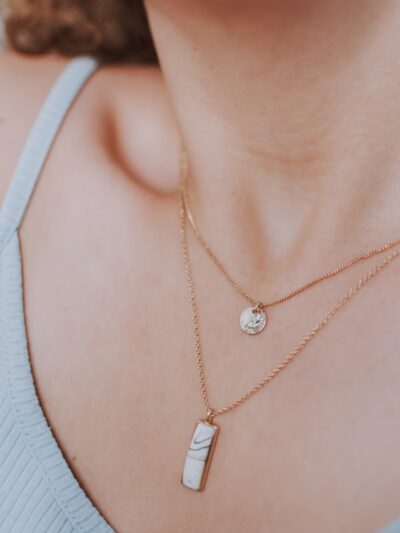 woman wearing gold necklace with silver pendant